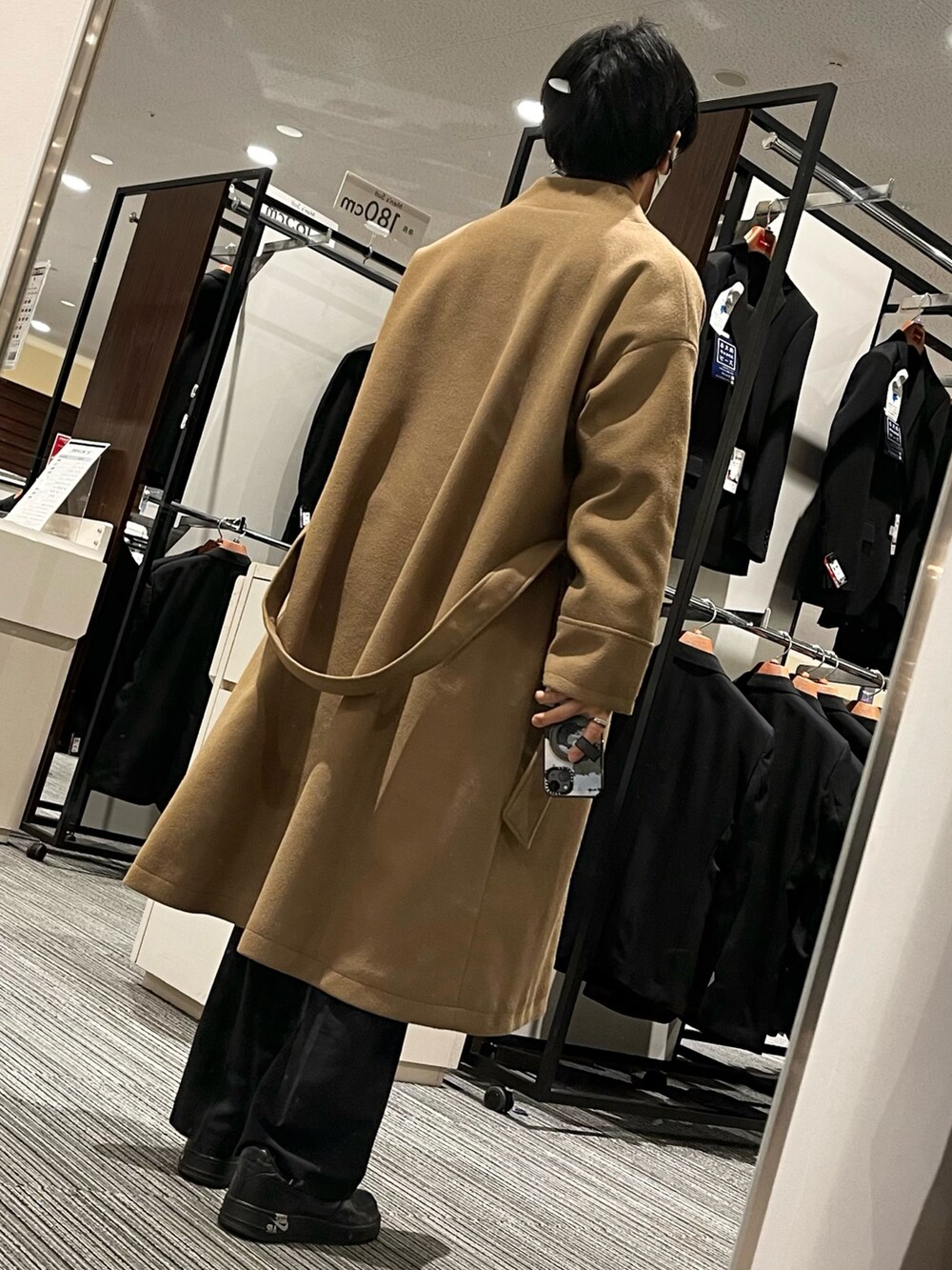 ブラック系のショルダーバッグ、ブラック系のスニーカー、ブラウン系のジャケット/アウターを着用したメンズの冬コーディネートの2枚目の写真