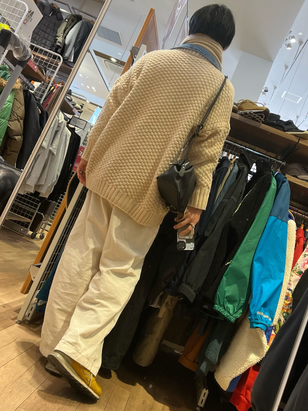 ホワイト系のパンツ、イエロー系のスニーカー、ブラック系のショルダーバッグを着用したメンズの冬コーディネートの2枚目の写真