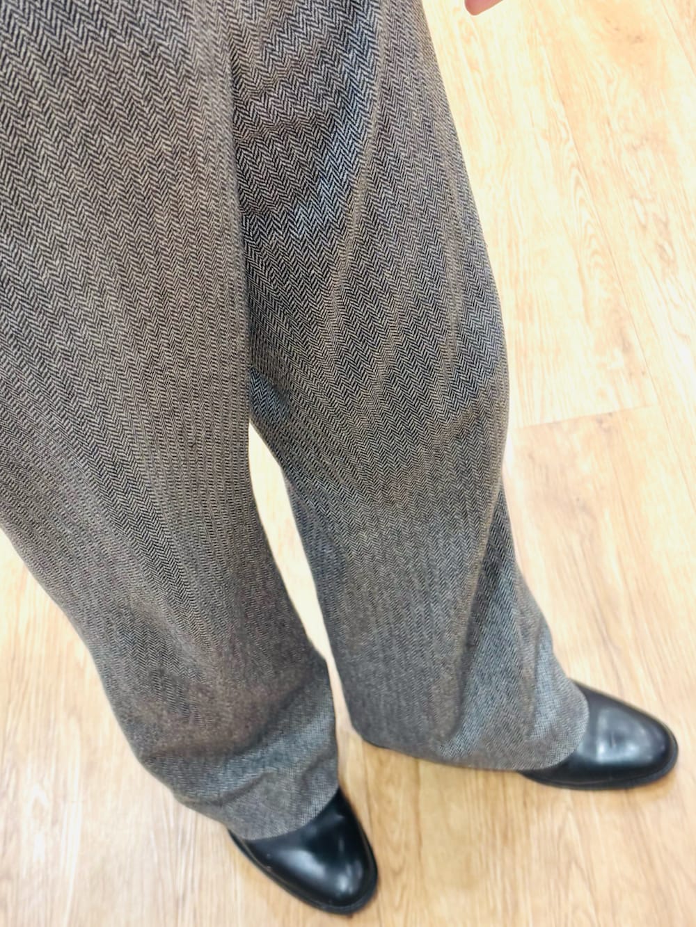 ブラック系のブーツ、ブルー系のジャケット/アウター、グレー系のスラックスを着用したメンズの春コーディネートの3枚目の写真