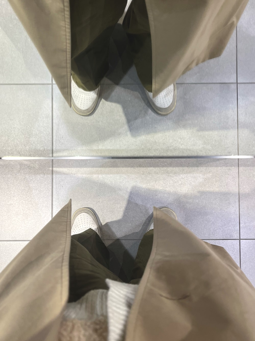 ブラック系のショルダーバッグ、グリーン系のパンツ、ホワイト系のスニーカーを着用したメンズの春コーディネートの5枚目の写真