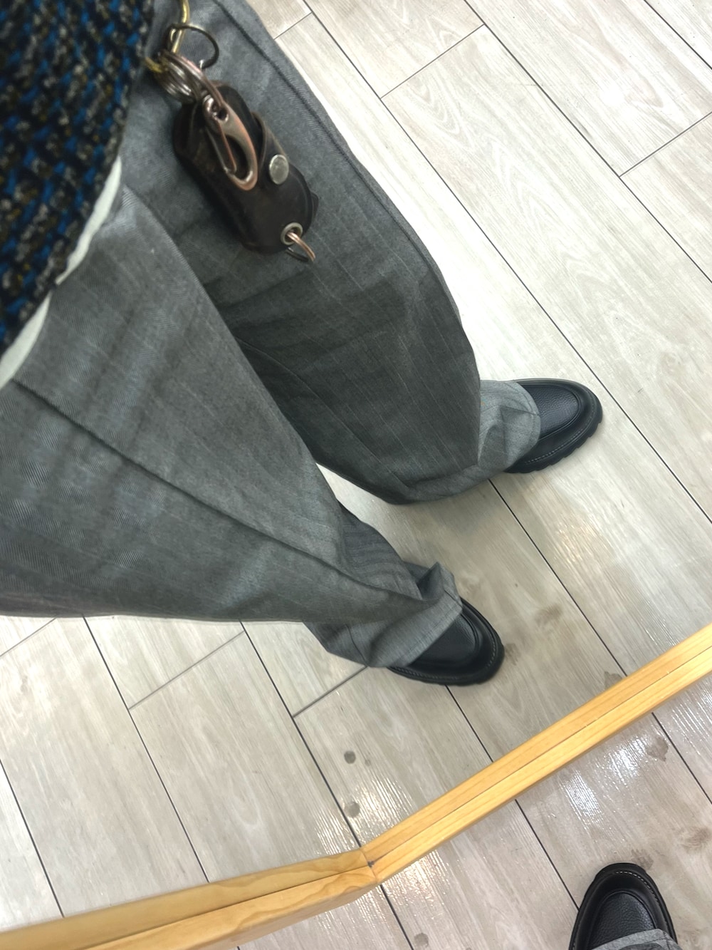 グレー系のスラックス、ブラック系のドレスシューズ、その他のニット/セーターを着用したメンズの春コーディネートの3枚目の写真