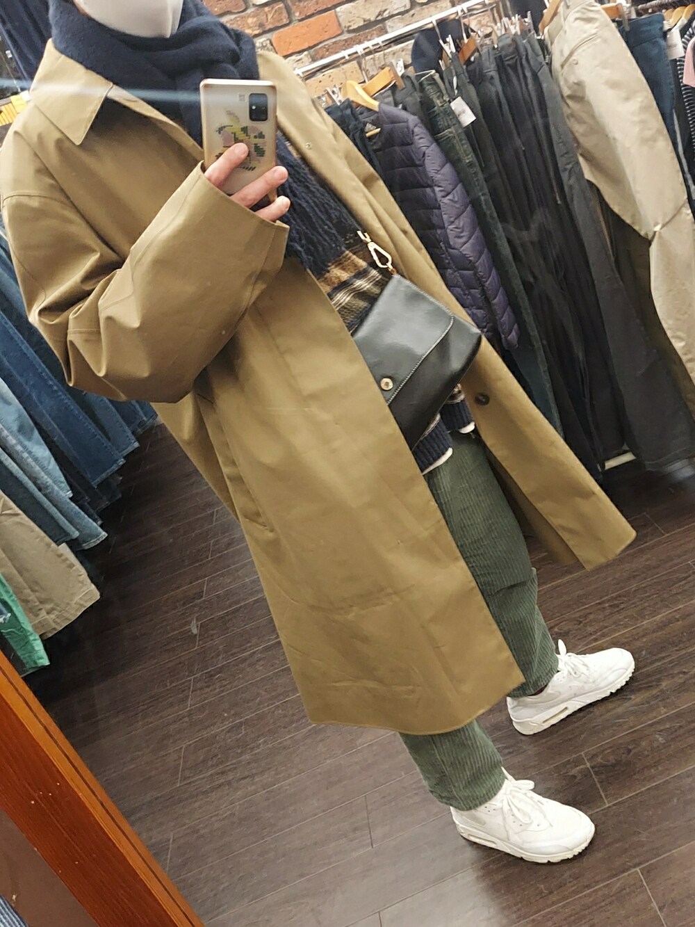 ホワイト系のスニーカー、ブラック系のバッグ、グリーン系のパンツを着用したメンズの冬コーディネートの5枚目の写真