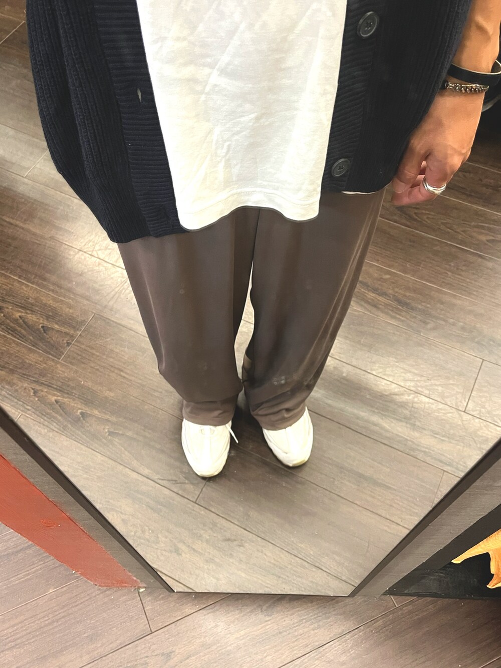 ホワイト系のスニーカー、ブラウン系のパンツ、ブルー系のベストを着用したメンズの秋コーディネートの5枚目の写真