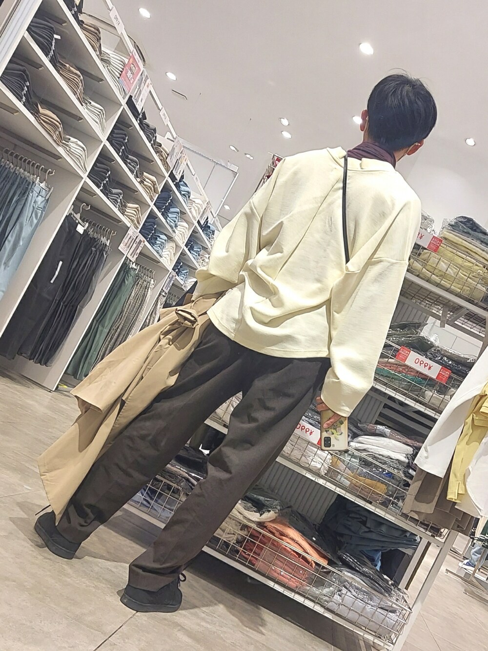 ブラウン系のパンツ、ブラック系のスニーカー、ホワイト系のニット/セーターを着用したメンズの春コーディネートの2枚目の写真