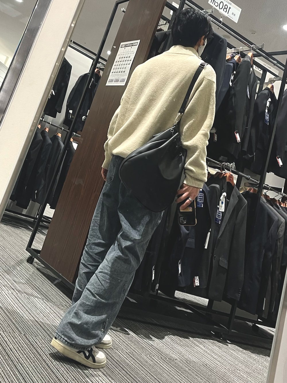 グレー系のデニムパンツ、ホワイト系のスニーカー、ホワイト系のニット/セーターを着用したメンズの春コーディネートの2枚目の写真