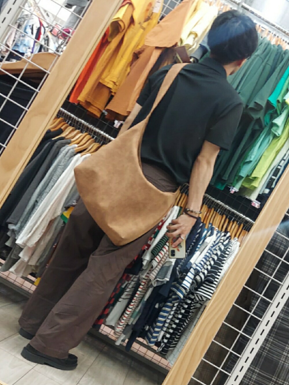 ブラック系のローファー、パープル系のパンツ、ブラック系のポロシャツを着用したメンズの夏コーディネートの2枚目の写真