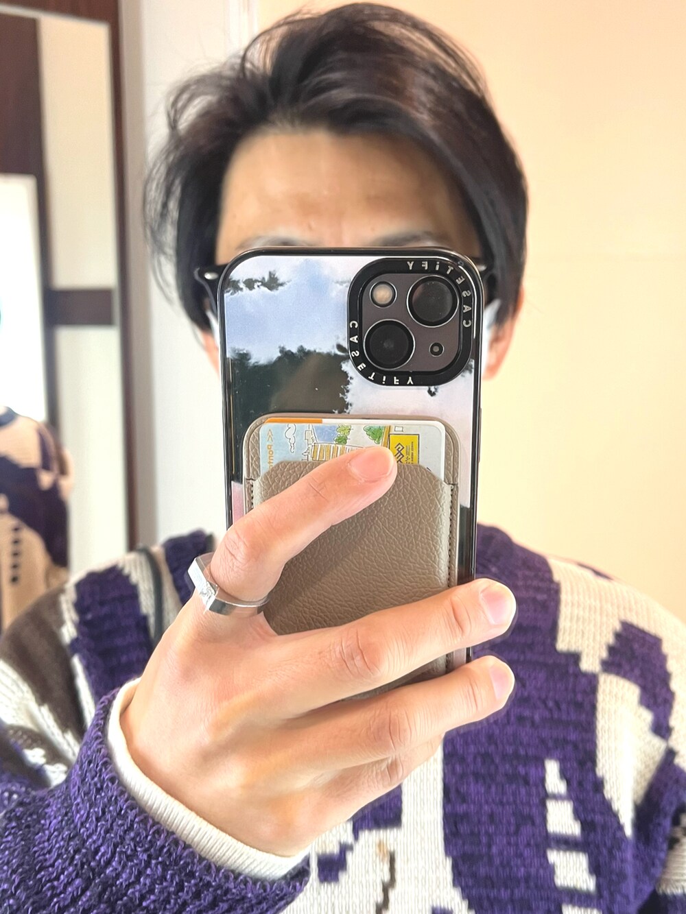 グレー系のスラックス、ブラック系のショルダーバッグ、パープル系のニット/セーターを着用したメンズの冬コーディネートの4枚目の写真