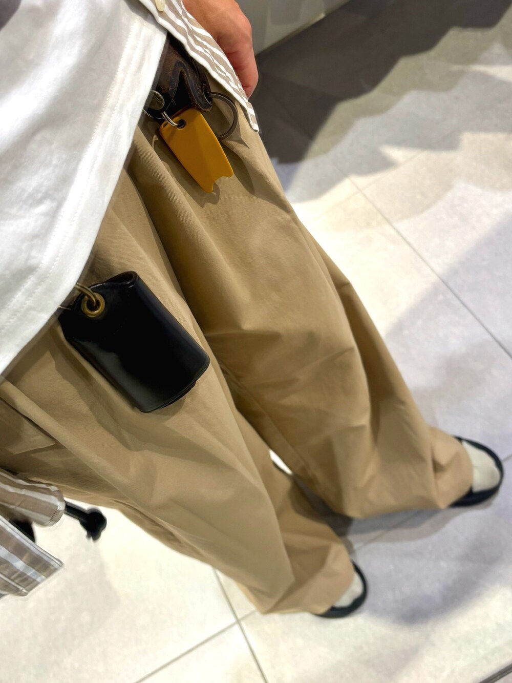 ベージュ系のチノパンツ、ブラック系のサンダル、ホワイト系のTシャツ/カットソーを着用したメンズの夏コーディネートの3枚目の写真