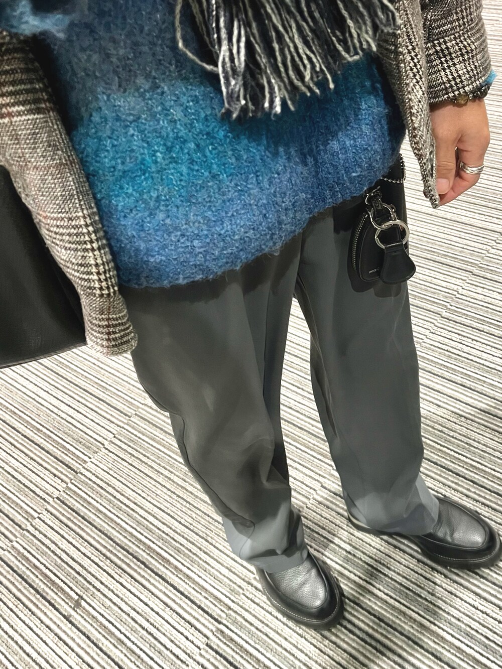 ブラック系のドレスシューズ、グレー系のスラックス、ブルー系のニット/セーターを着用したメンズの冬コーディネートの3枚目の写真