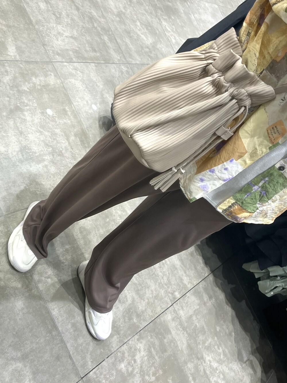 ホワイト系のスニーカー、ブラウン系のパンツ、ホワイト系のボディバッグ/ウエストポーチを着用したメンズの秋コーディネートの3枚目の写真