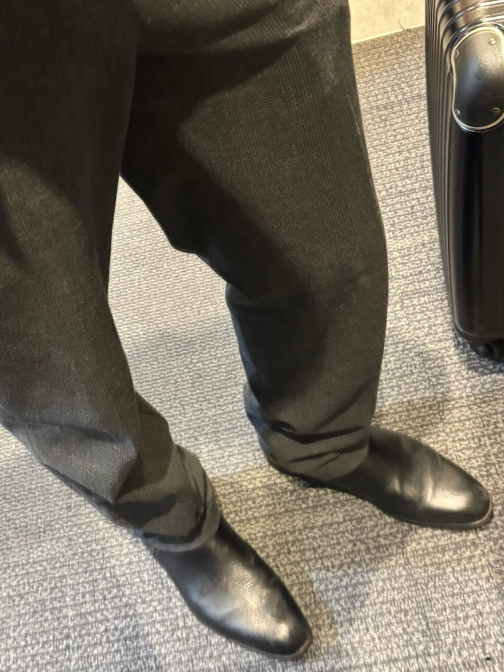 グレー系のスラックス、その他のビジネスシャツ、ブラック系のブルゾンを着用したメンズの春コーディネートの3枚目の写真