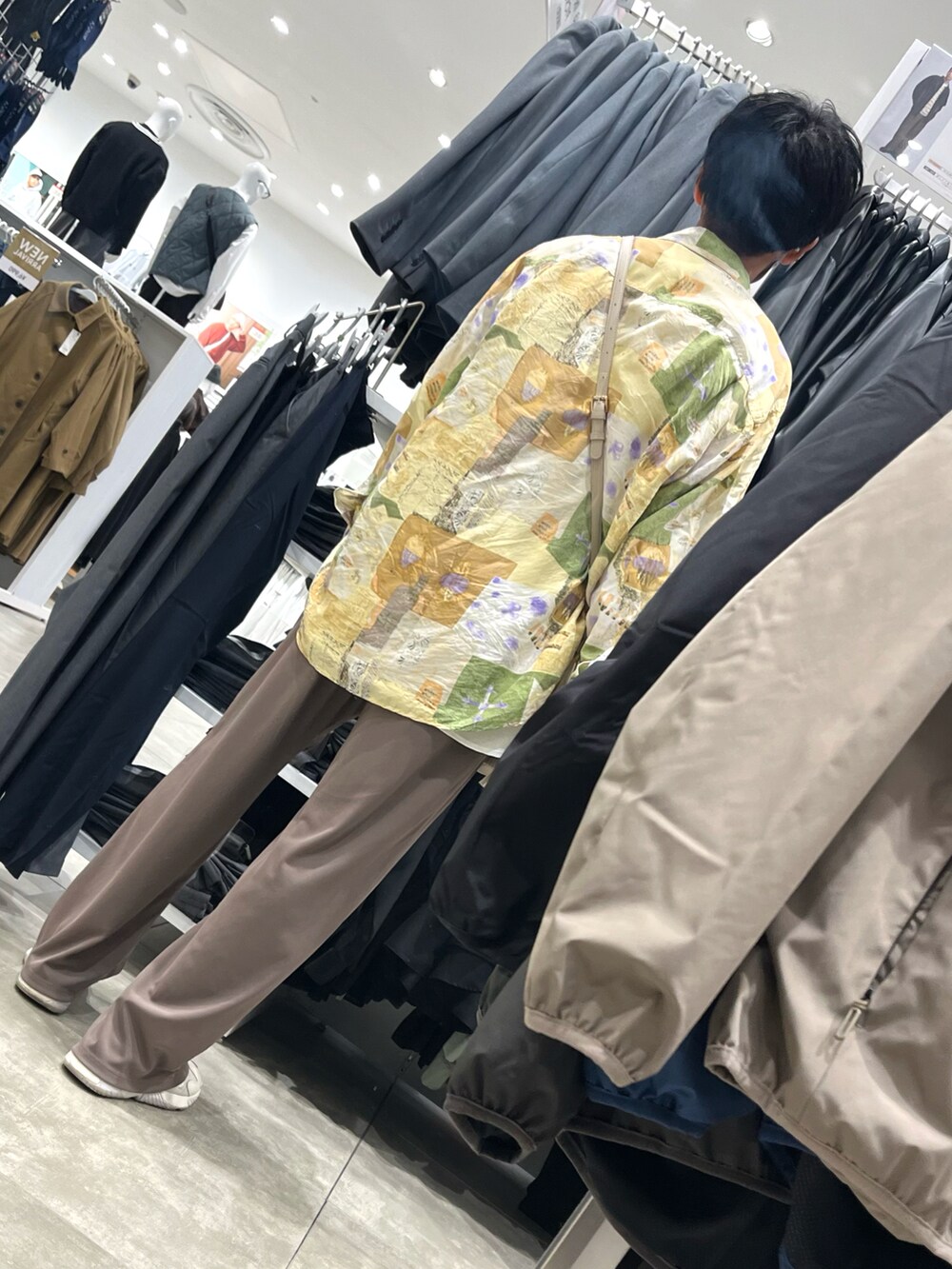 ホワイト系のスニーカー、ブラウン系のパンツ、ホワイト系のボディバッグ/ウエストポーチを着用したメンズの秋コーディネートの2枚目の写真