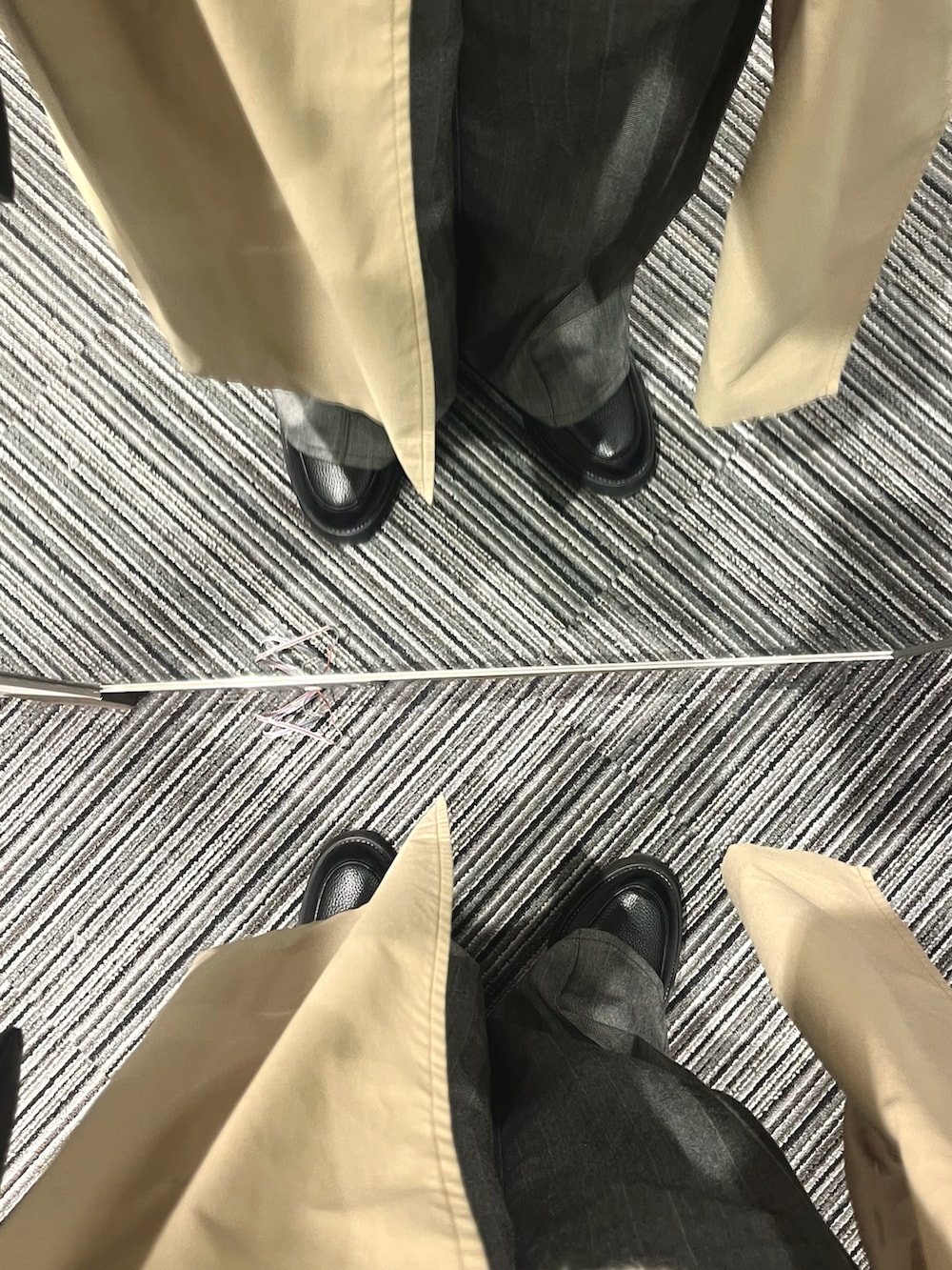 ブラック系のドレスシューズ、グレー系のスラックス、ホワイト系のニット/セーターを着用したメンズの春コーディネートの5枚目の写真