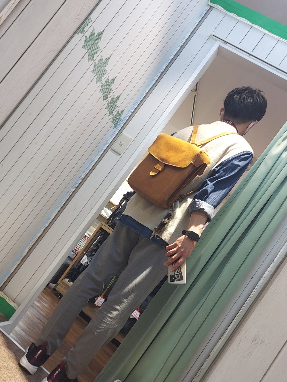 ブラック系のサンダル、グレー系のスラックス、ベージュ系のベストを着用したメンズの春コーディネートの2枚目の写真