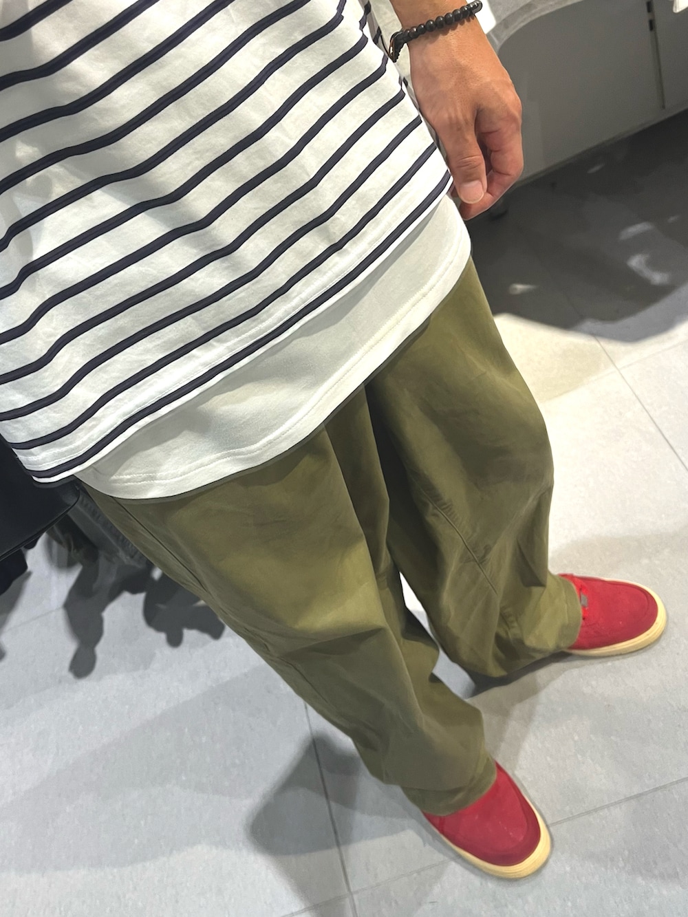 グリーン系のパンツ、レッド系のスニーカー、ホワイト系のTシャツ/カットソーを着用したメンズの秋コーディネートの3枚目の写真