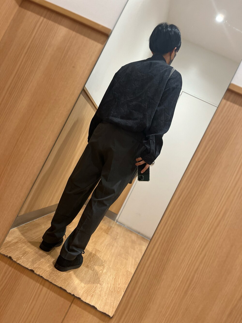 ブラウン系のパンツ、ブラック系のスニーカー、グレー系のショルダーバッグを着用したメンズの秋コーディネートの2枚目の写真