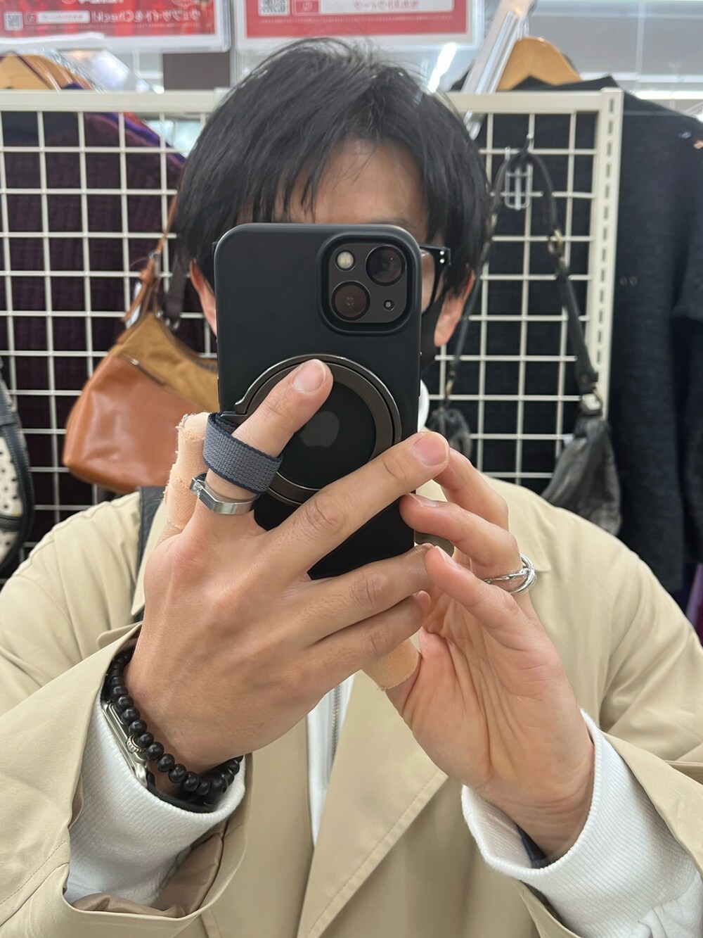 ブラック系のスニーカー、ベージュ系のトレンチコート、ブラック系のショルダーバッグを着用したメンズの冬コーディネートの4枚目の写真