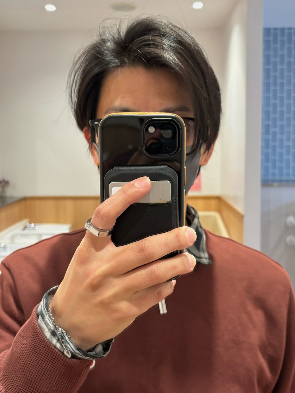 ブラウン系のスウェット、ブラウン系のショルダーバッグ、ブラック系のドレスシューズを着用したメンズの冬コーディネートの4枚目の写真