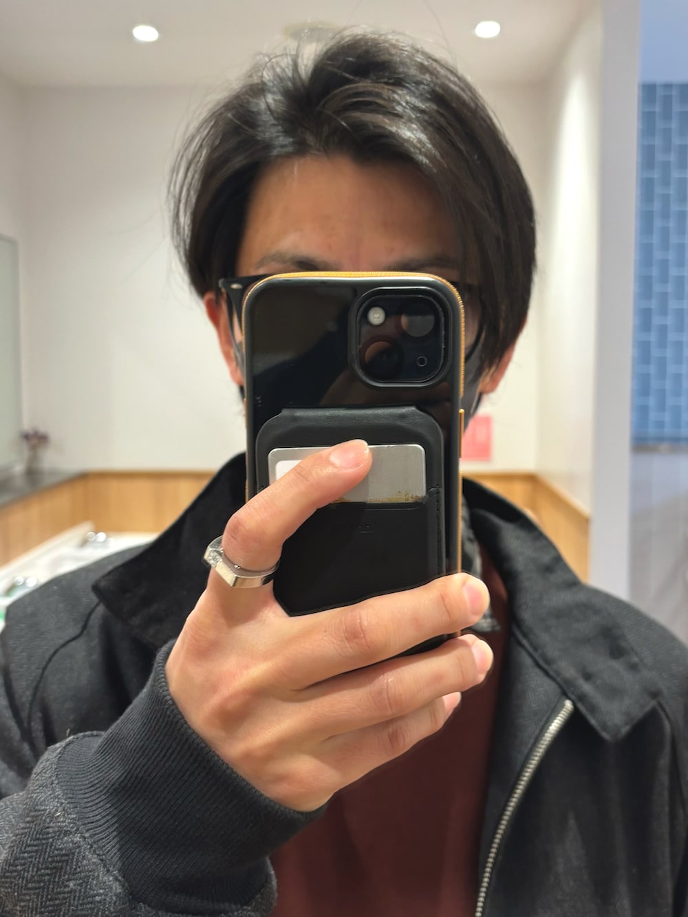 ブラック系のブルゾン、ブラウン系のスウェット、ブラウン系のショルダーバッグを着用したメンズの冬コーディネートの4枚目の写真