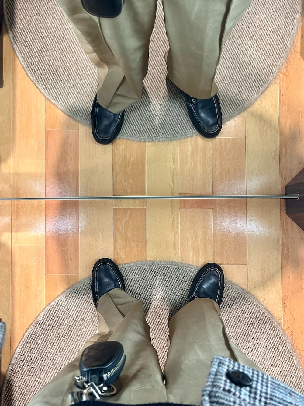 ベージュ系のパンツ、ブラック系のローファー、ブラック系のショルダーバッグを着用したメンズの冬コーディネートの5枚目の写真