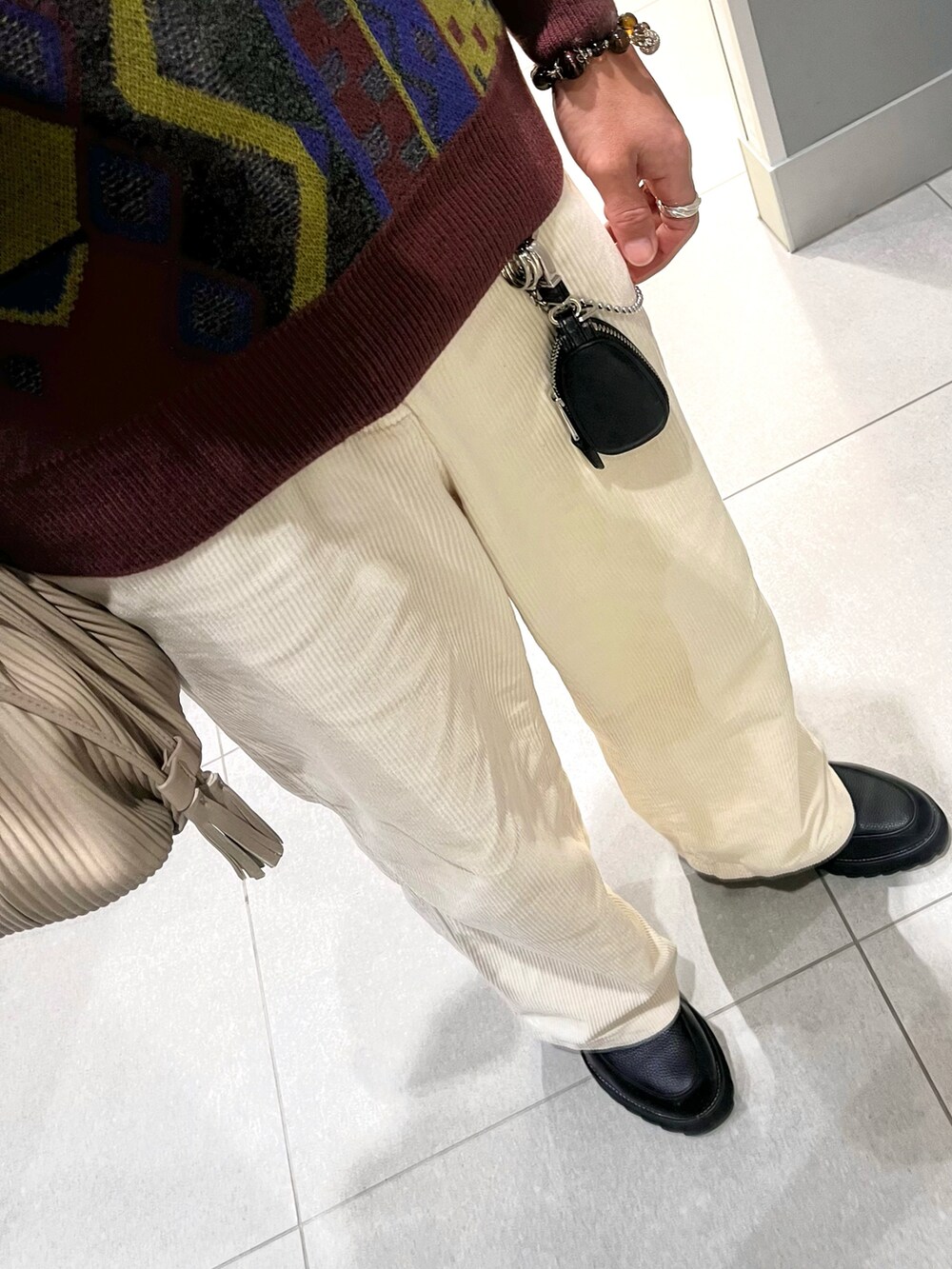 ホワイト系のパンツ、ブラック系のドレスシューズ、その他のニット/セーターを着用したメンズの春コーディネートの3枚目の写真