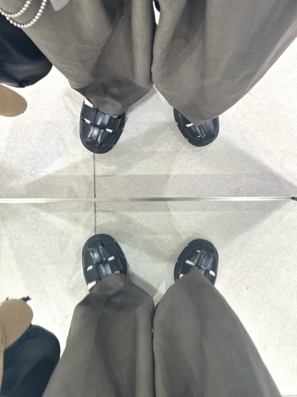 グレー系のスラックス、ホワイト系のタンクトップ、ブルー系のシャツ/ブラウスを着用したメンズの夏コーディネートの5枚目の写真