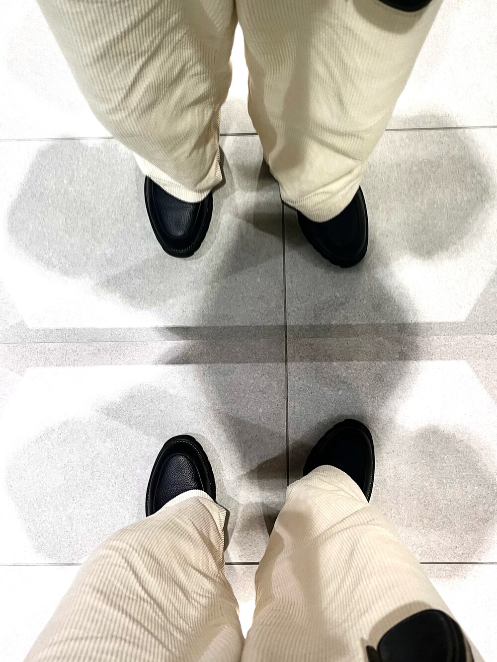 ホワイト系のパンツ、ブラック系のドレスシューズ、その他のニット/セーターを着用したメンズの春コーディネートの5枚目の写真