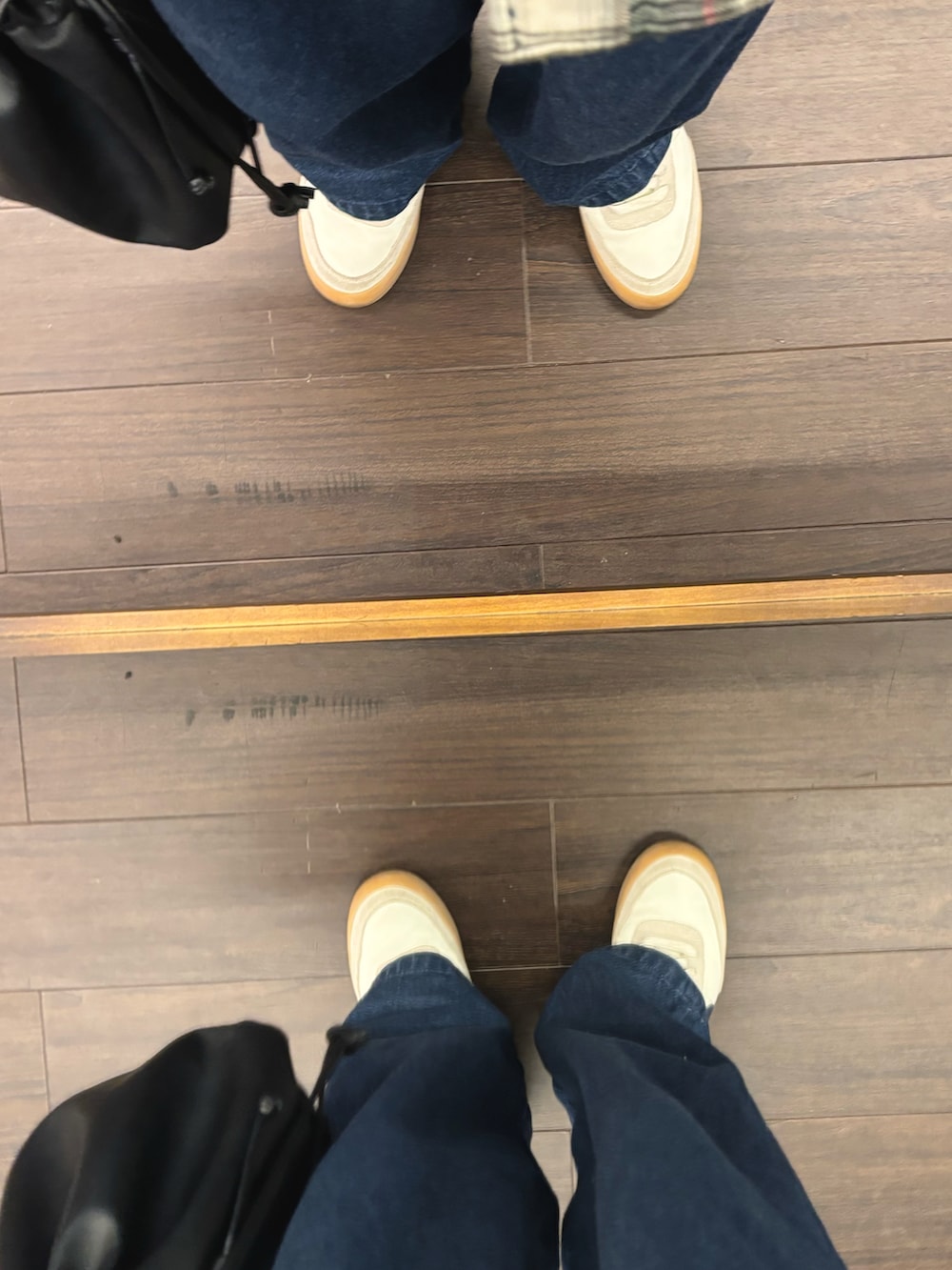 ホワイト系のスニーカー、ブルー系のデニムパンツ、グレー系のスウェットを着用したメンズの冬コーディネートの5枚目の写真