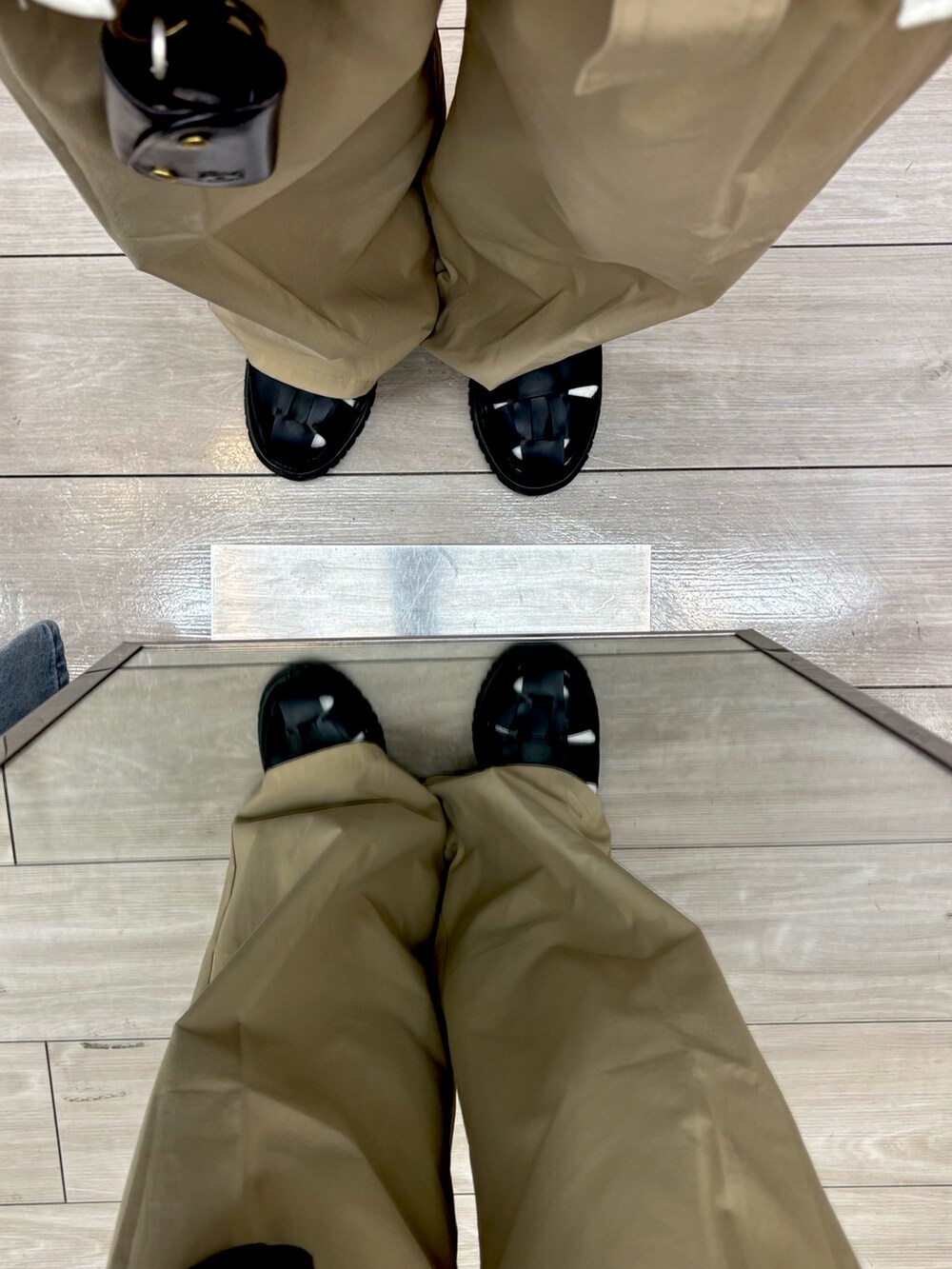 ベージュ系のチノパンツ、ブラック系のサンダル、ブラック系のTシャツ/カットソーを着用したメンズの夏コーディネートの5枚目の写真