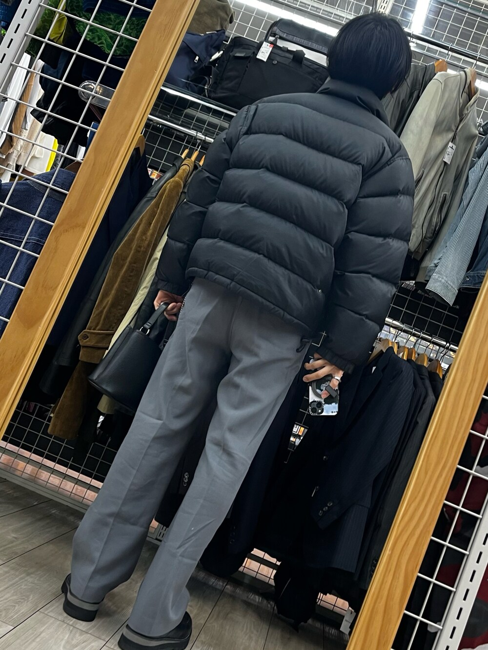 ブラック系のダウンジャケット/コート、ブラック系のショルダーバッグ、ブラック系のドレスシューズを着用したメンズの冬コーディネートの2枚目の写真