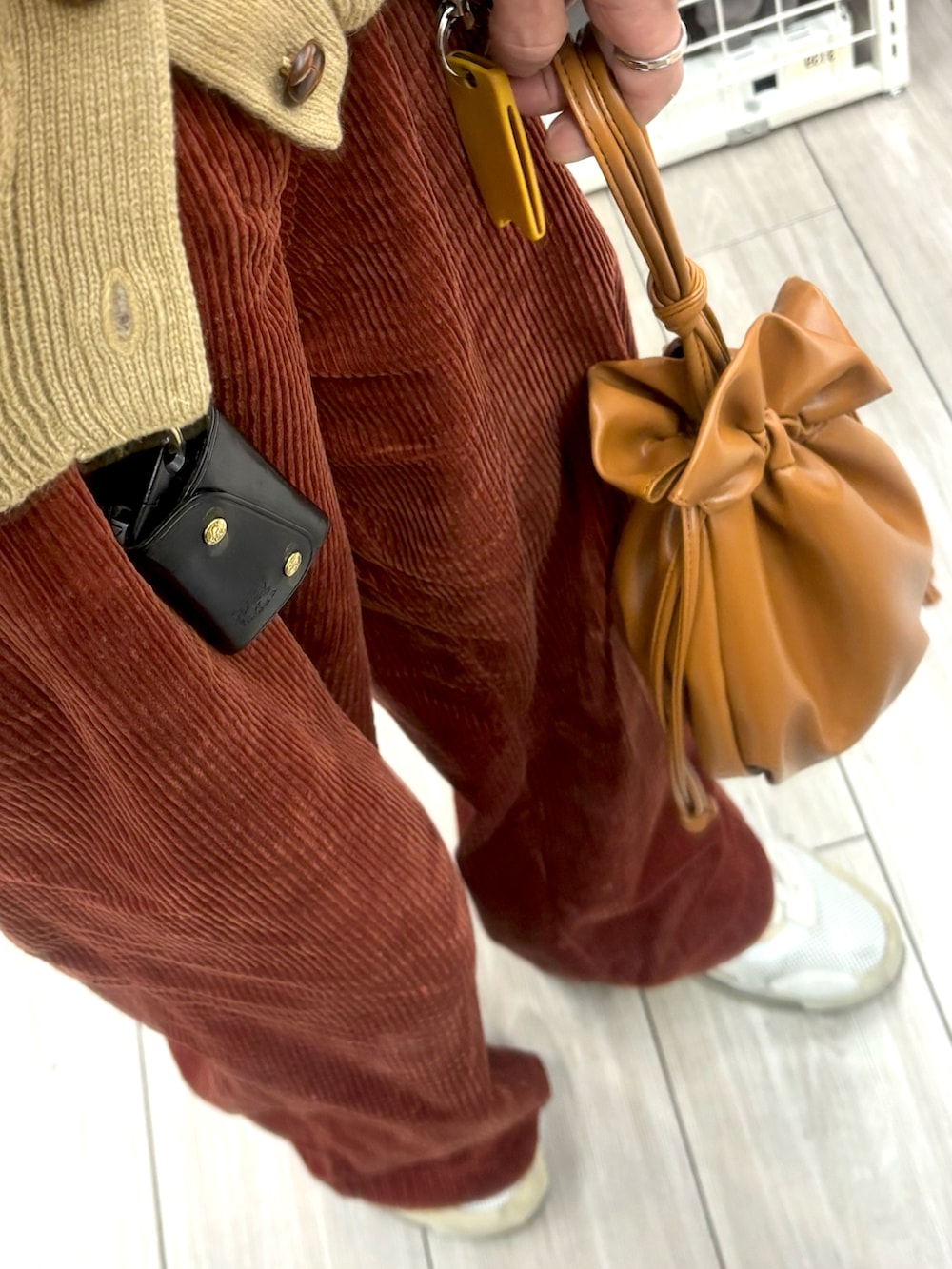 ブラウン系のショルダーバッグ、ブラウン系のカーディガン/ボレロ、レッド系のその他パンツを着用したメンズの冬コーディネートの3枚目の写真