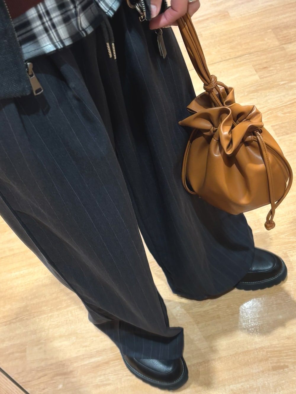 ブラック系のブルゾン、ブラウン系のスウェット、ブラウン系のショルダーバッグを着用したメンズの冬コーディネートの3枚目の写真