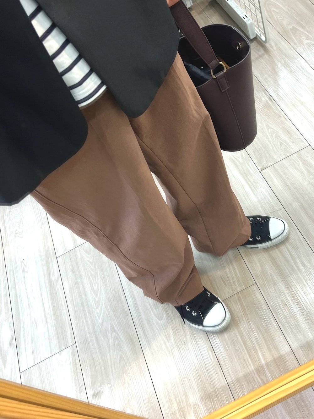 ブラウン系のハンドバッグ、ブラック系のテーラードジャケット、ホワイト系のTシャツ/カットソーを着用したメンズの春コーディネートの3枚目の写真