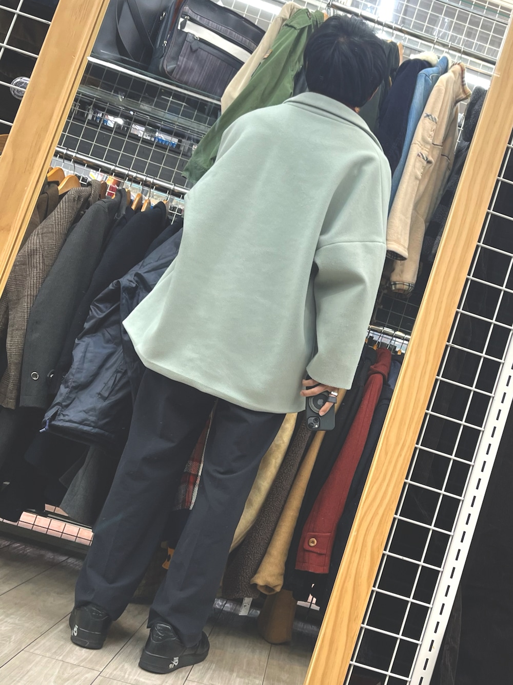 レッド系のニット/セーター、グリーン系のジャケット/アウター、グレー系のショルダーバッグを着用したメンズの冬コーディネートの2枚目の写真