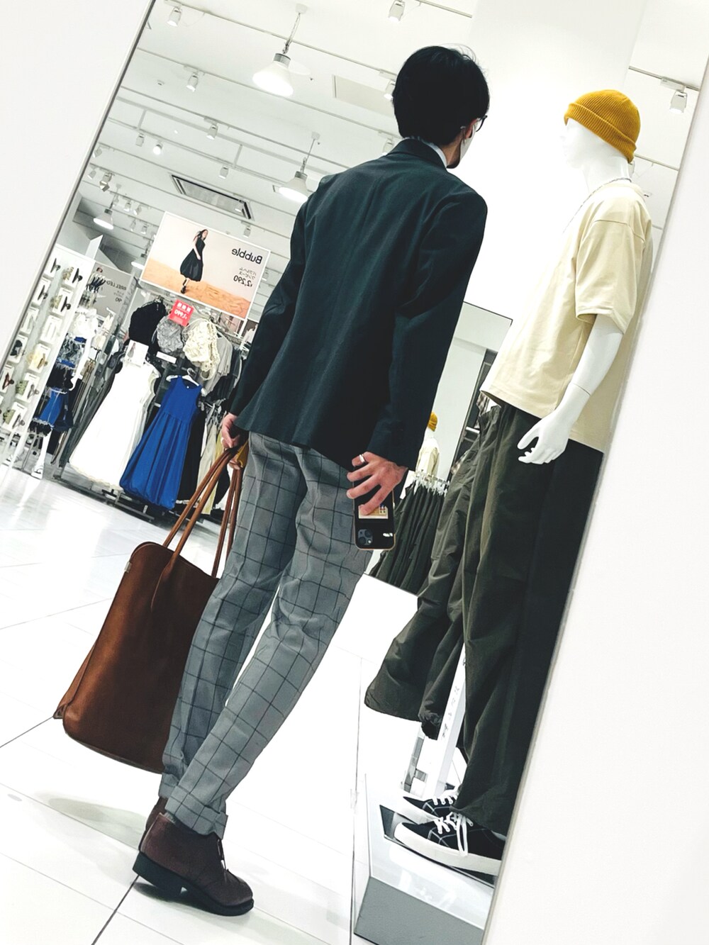 ブラウン系のドレスシューズ、グレー系のスラックス、ブラウン系のトートバッグを着用したメンズの春コーディネートの2枚目の写真