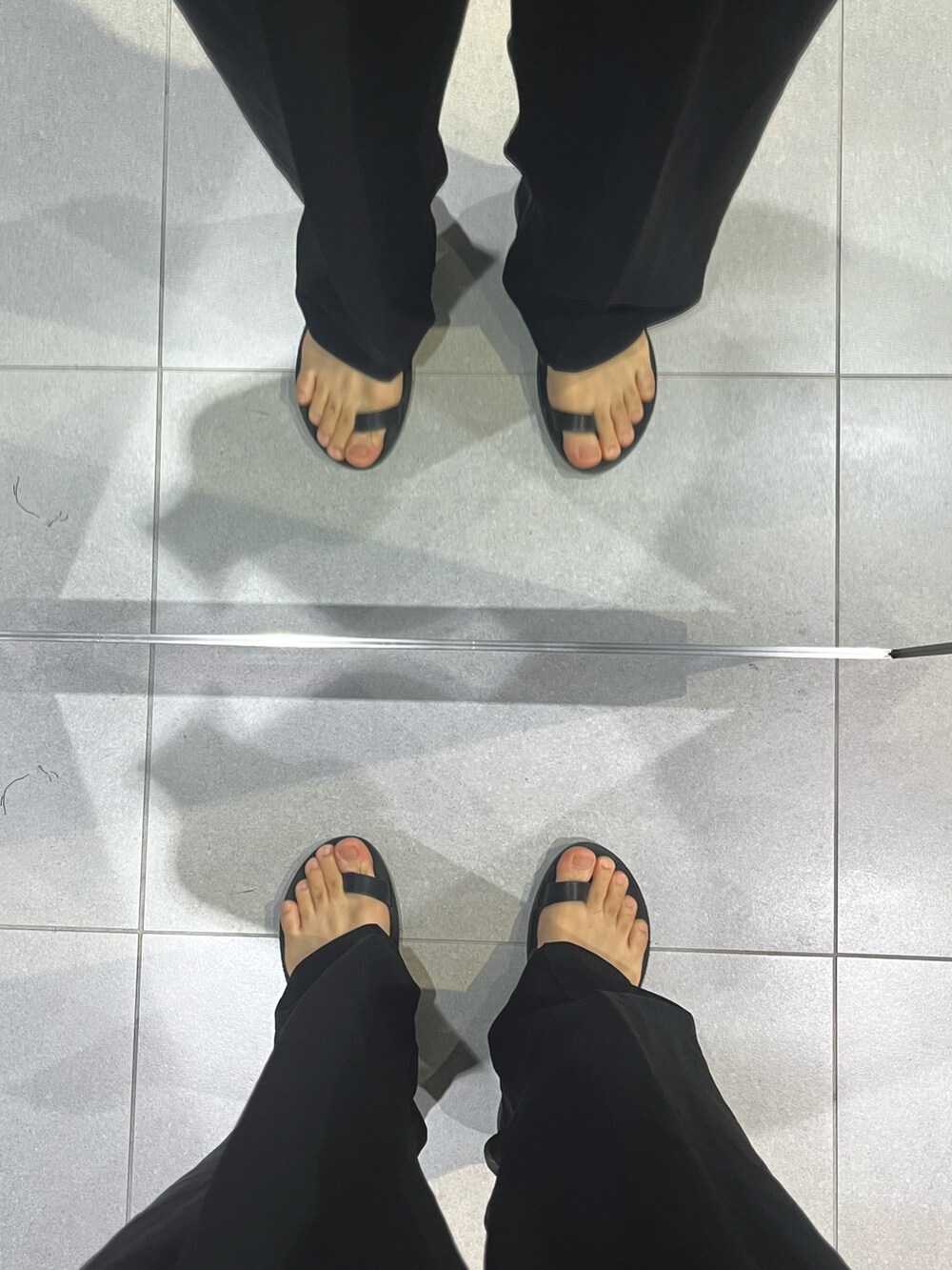 ブラック系のスラックス、ブラック系のサンダル、ブラック系のショルダーバッグを着用したメンズの秋コーディネートの5枚目の写真