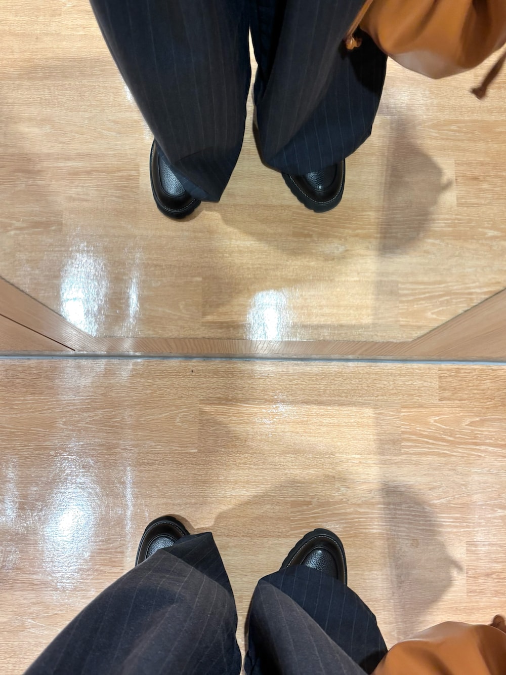 ブラウン系のスウェット、ブラウン系のショルダーバッグ、ブラック系のドレスシューズを着用したメンズの冬コーディネートの5枚目の写真