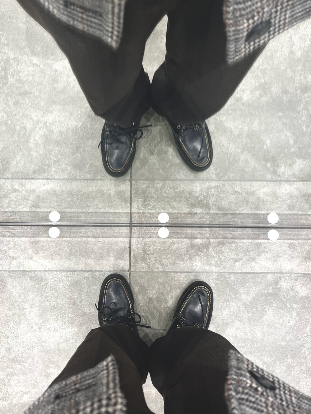 ブラウン系のパンツ、ブラック系のローファー、その他のジャケット/アウターを着用したメンズの冬コーディネートの5枚目の写真