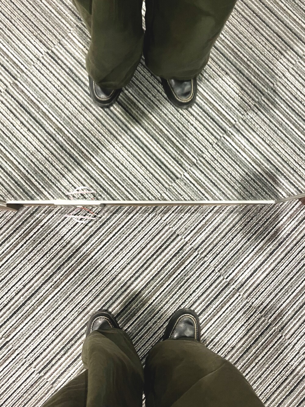 ブラック系のローファー、グリーン系のパンツ、ブラック系のショルダーバッグを着用したメンズの冬コーディネートの5枚目の写真