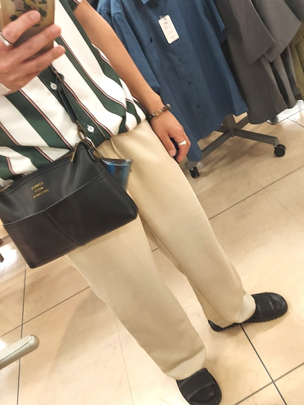 ブラック系のショルダーバッグ、ベージュ系のパンツ、ブラック系のサンダルを着用したメンズの夏コーディネートの3枚目の写真