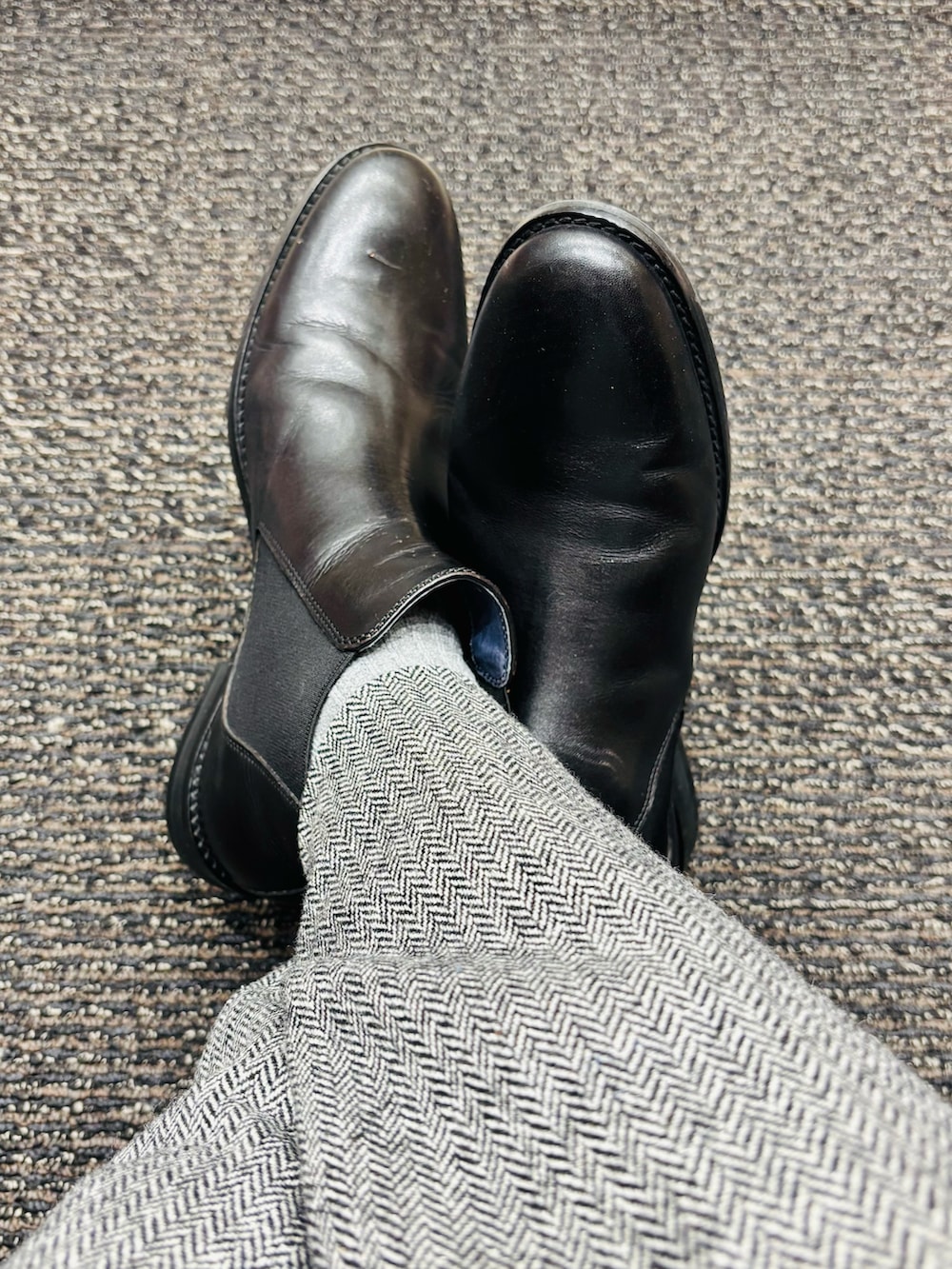 ブラック系のブーツ、ブルー系のジャケット/アウター、グレー系のスラックスを着用したメンズの春コーディネートの5枚目の写真