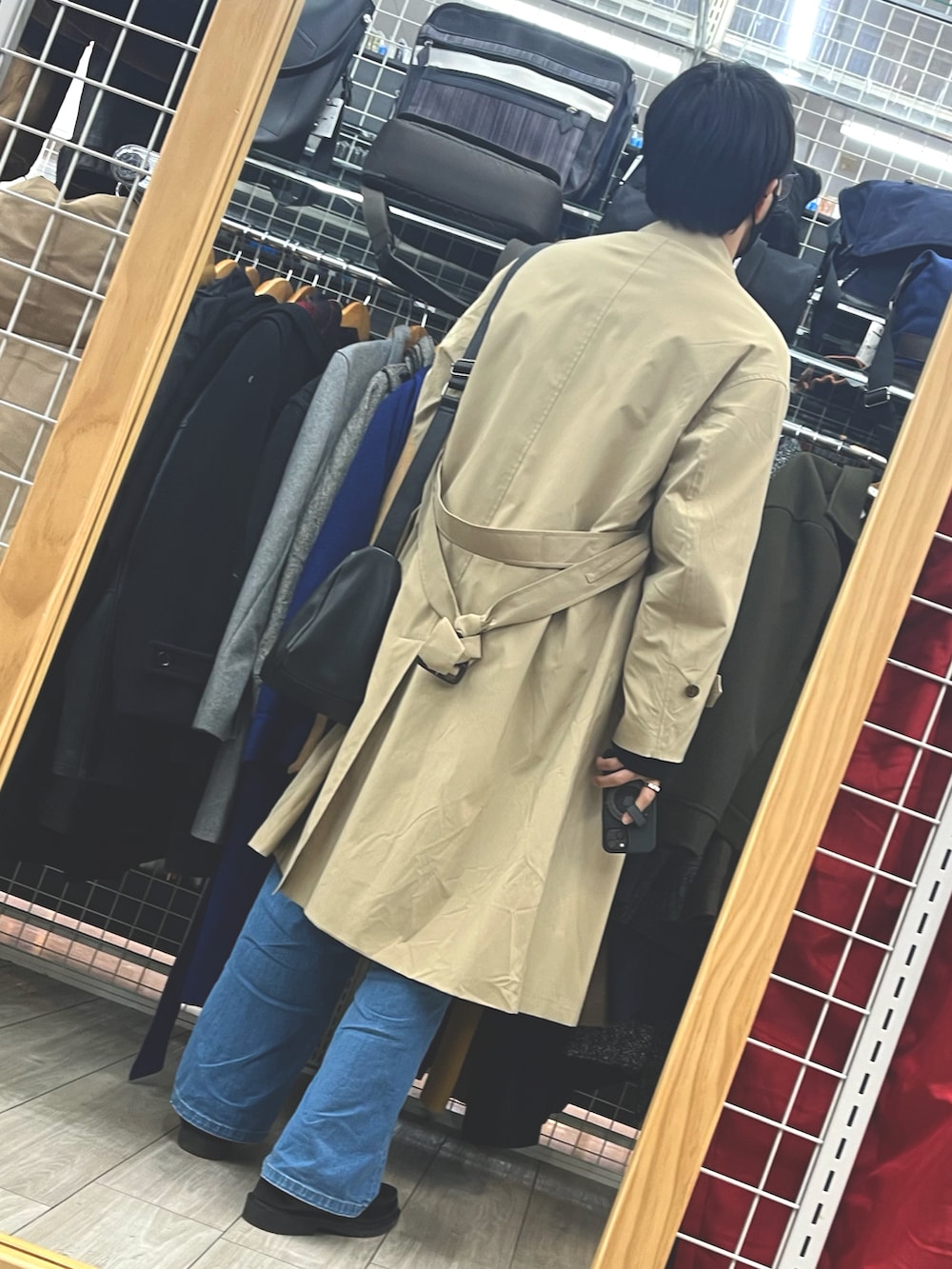 ブラック系のローファー、ブルー系のデニムパンツ、ブラウン系のステンカラーコートを着用したメンズの冬コーディネートの2枚目の写真