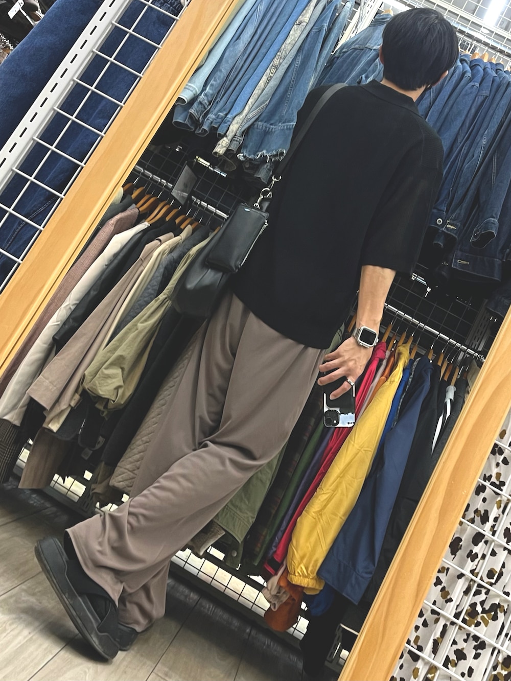 ブラウン系のパンツ、ブラック系のポロシャツ、ブラック系のサンダルを着用したメンズの秋コーディネートの2枚目の写真