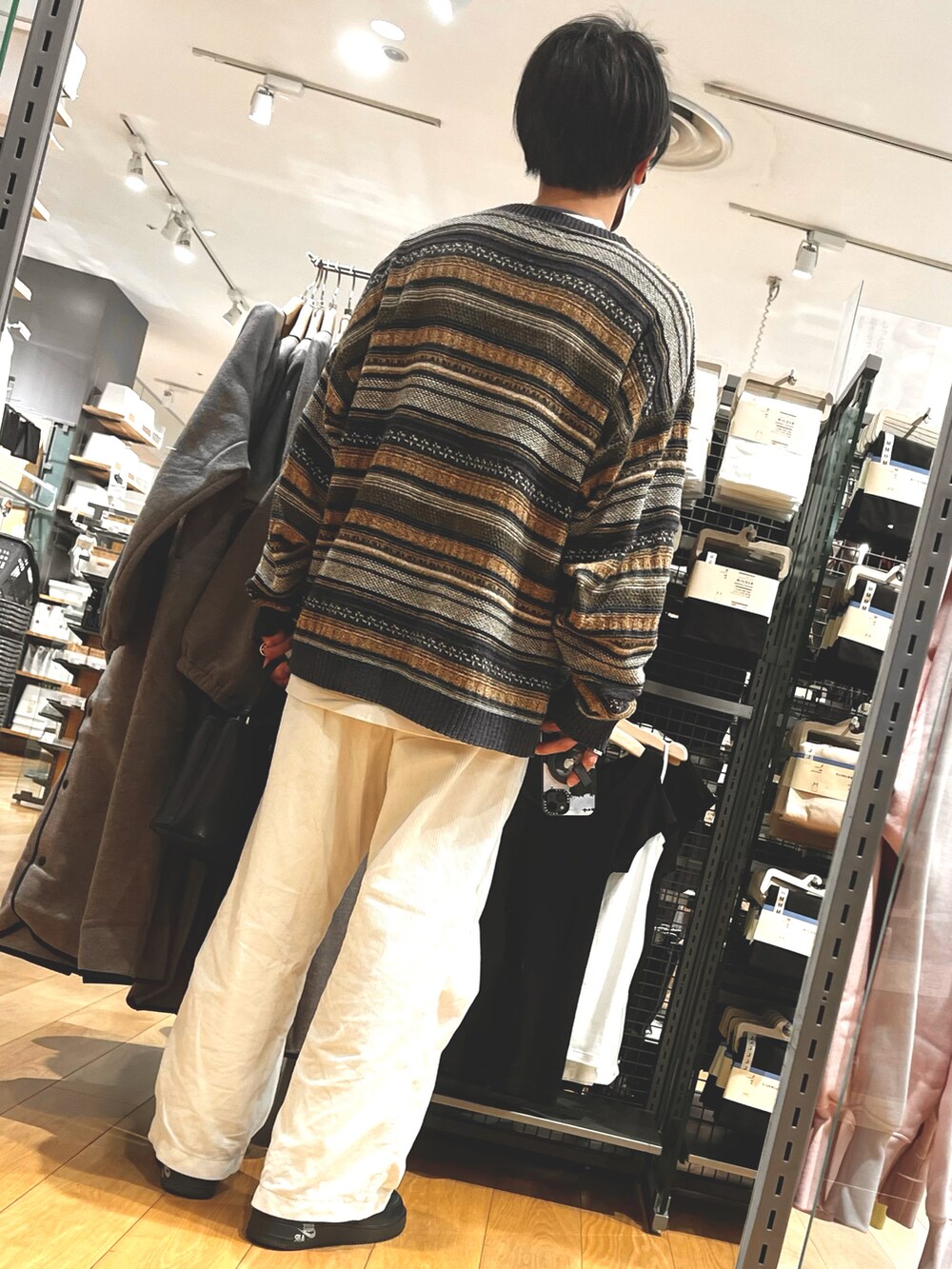 ホワイト系のパンツ、ブラック系のスニーカー、ブラック系のショルダーバッグを着用したメンズの冬コーディネートの2枚目の写真