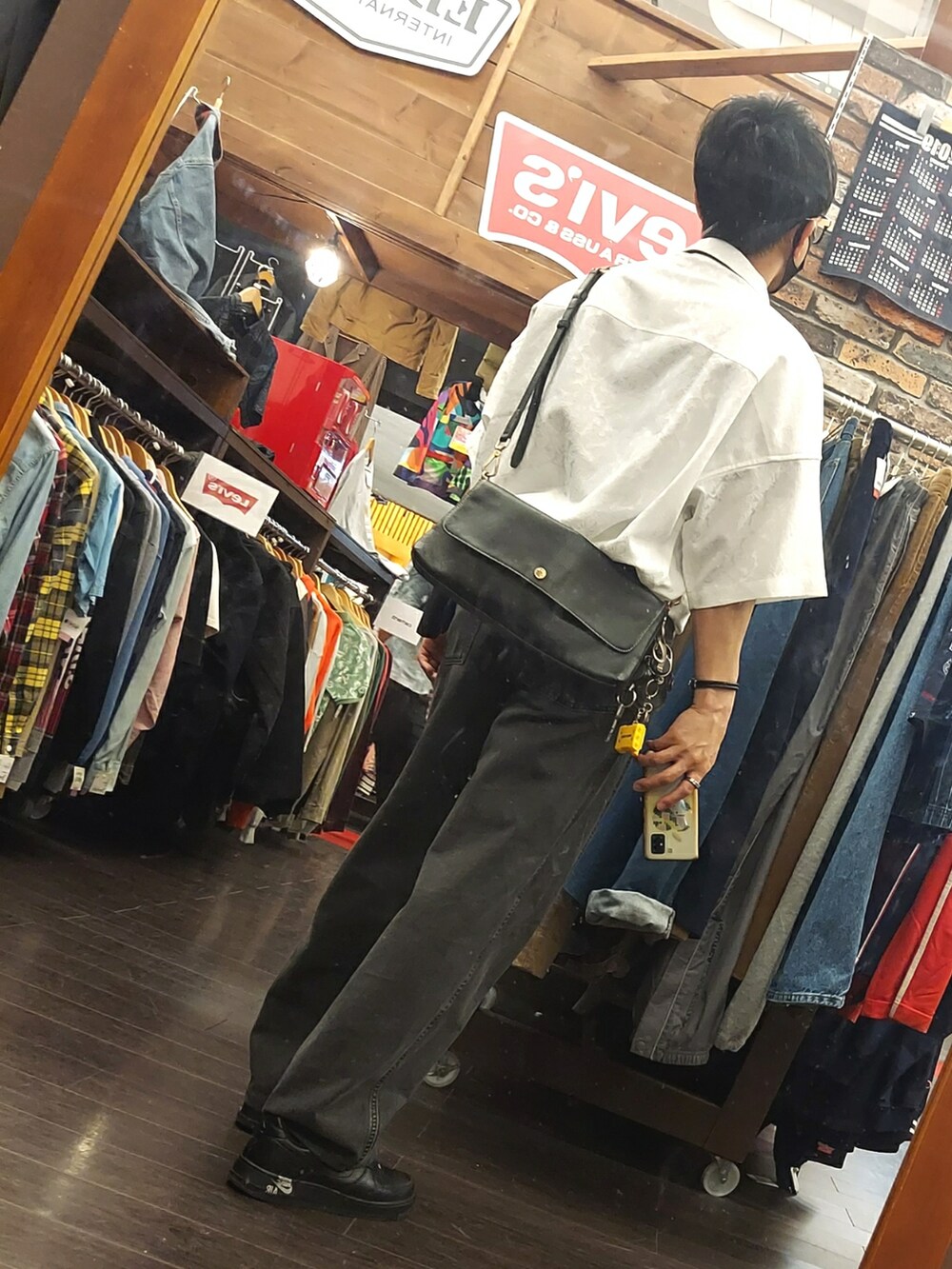 ブラック系のパンツ、ブラック系のスニーカー、ホワイト系のシャツ/ブラウスを着用したメンズの夏コーディネートの2枚目の写真