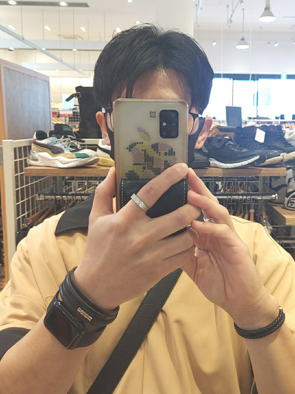 ブルー系のデニムパンツ、ブラック系のスニーカー、ベージュ系のシャツ/ブラウスを着用したメンズの春コーディネートの4枚目の写真