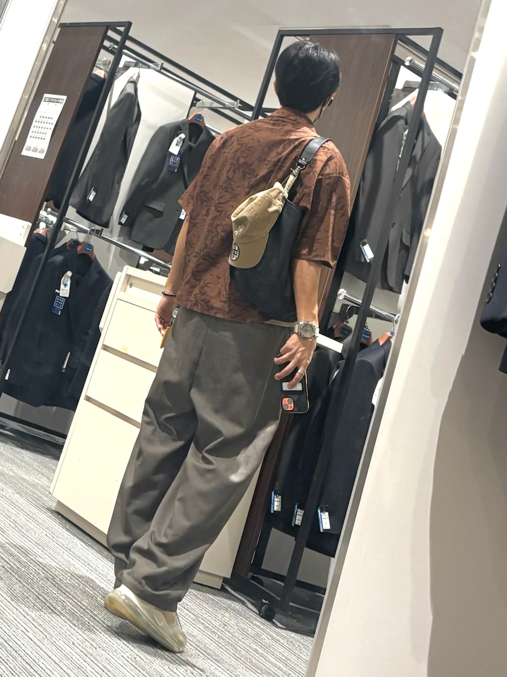 グレー系のスラックス、ベージュ系のタンクトップ、ブラウン系のシャツ/ブラウスを着用したメンズの秋コーディネートの2枚目の写真