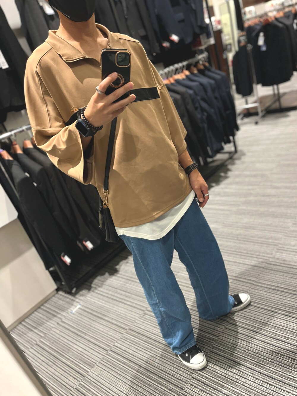 ブラック系のスニーカー、ブラック系のバッグ、ブルー系のデニムパンツを着用したメンズの秋コーディネートの5枚目の写真