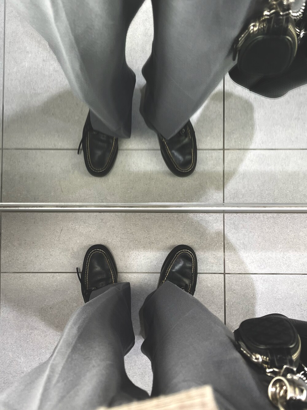 ブルー系のパンツ、ブラック系のローファー、ブラック系のショルダーバッグを着用したメンズの冬コーディネートの5枚目の写真