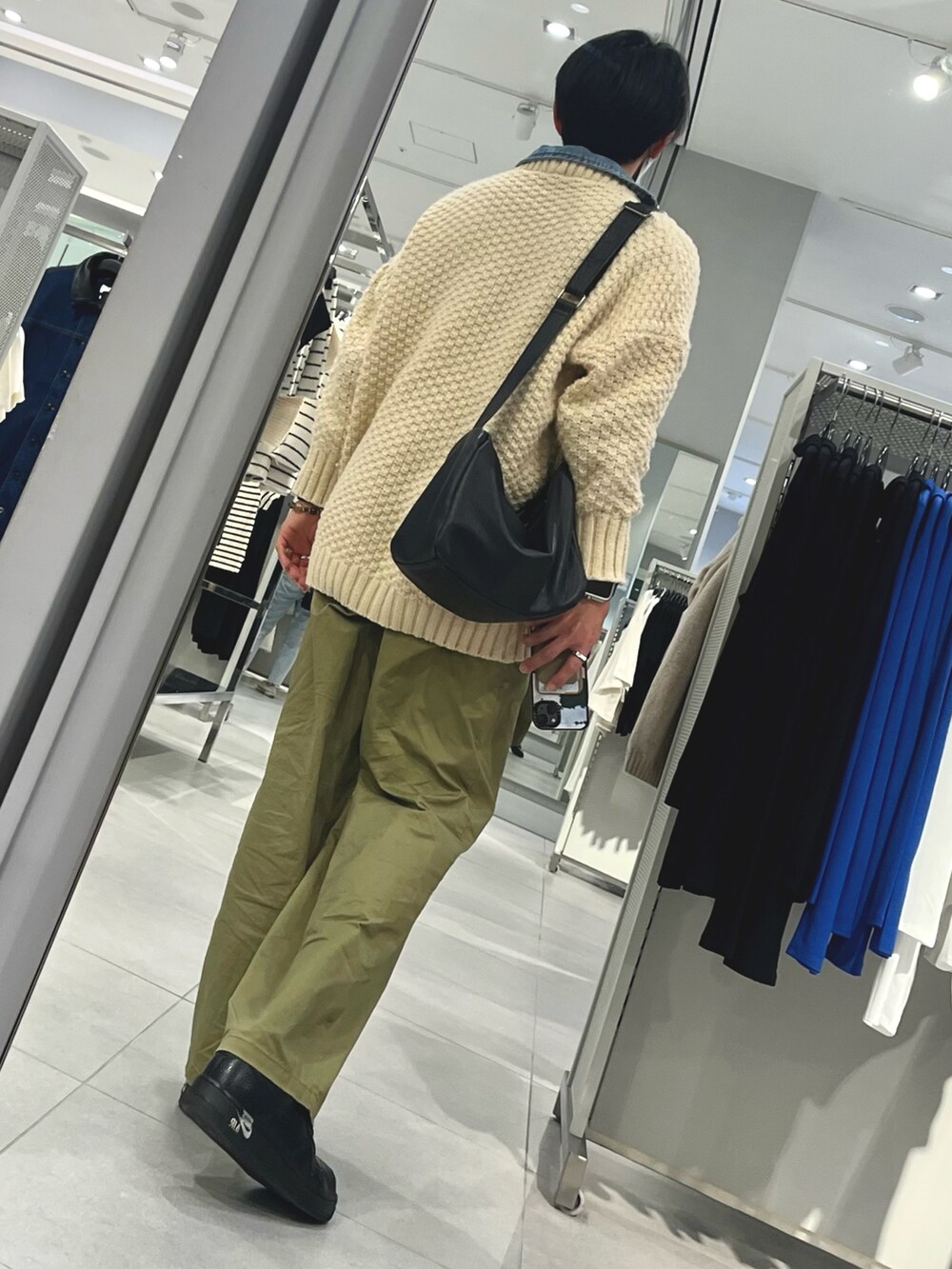 グリーン系のパンツ、ブラック系のスニーカー、ベージュ系のカーディガン/ボレロを着用したメンズの冬コーディネートの2枚目の写真